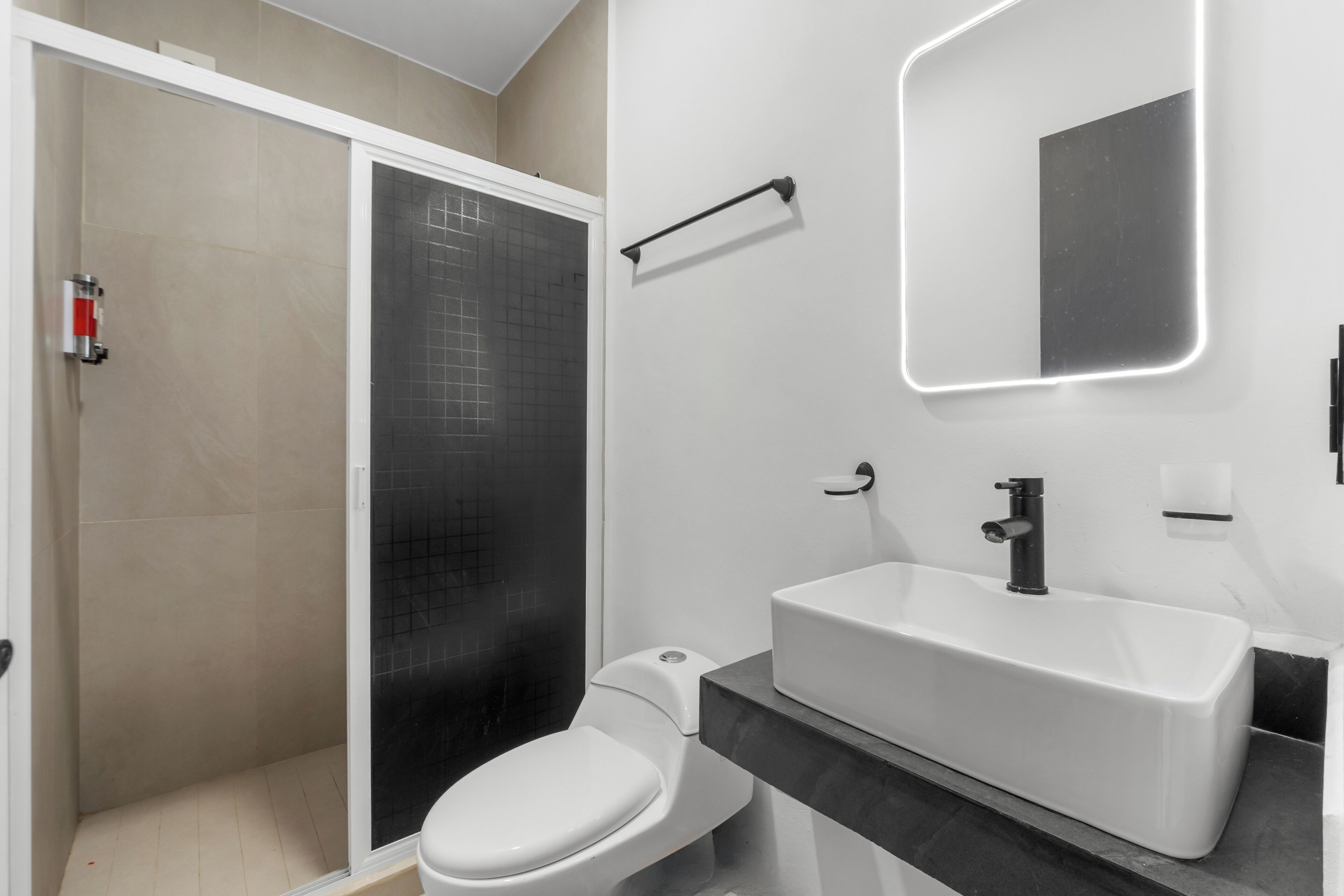 A modern bathroom with a shower, toilet, and sink.