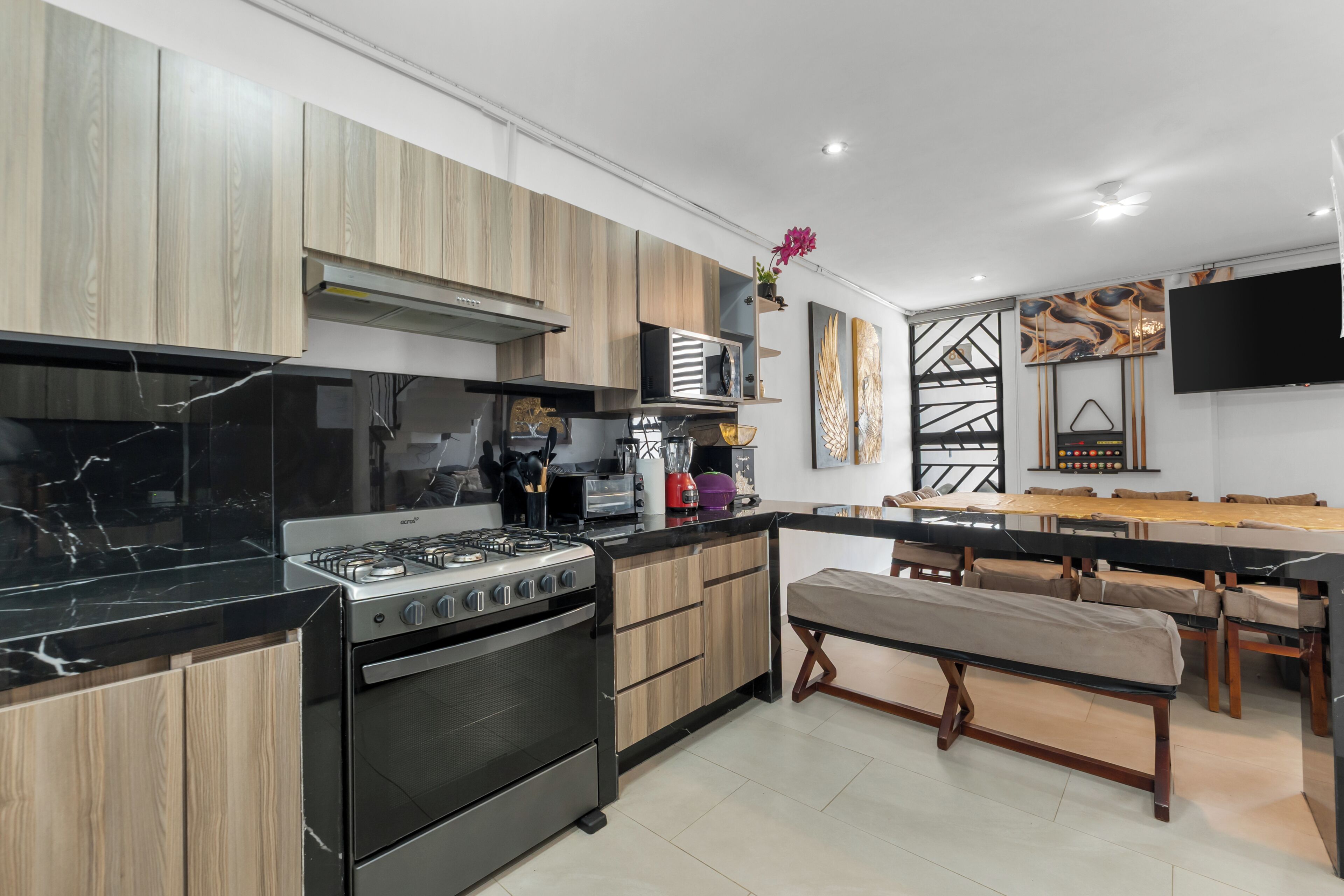 A modern kitchen with a gas stove, oven, and wooden cabinets.