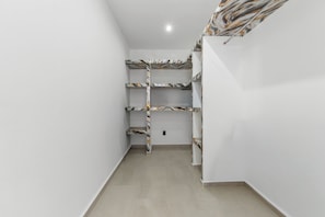 A narrow hallway with white walls and a tiled floor.