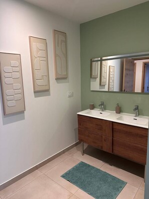 A bathroom with a double sink vanity, a large mirror, and wall art. - The Volcanoes Refuge (Saint-Pierre-le-Chastel)