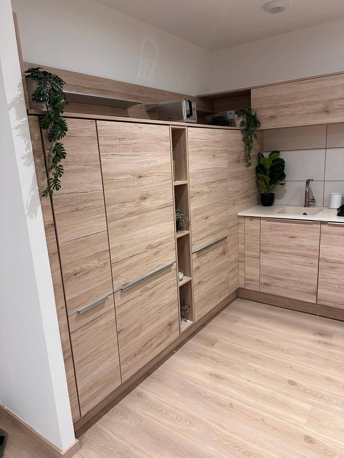 Een moderne keuken met houten kastjes, een spoelbak en een aanrecht.