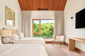Une chambre d’hôtel avec un grand lit, un bureau, une chaise, une télévision et une fenêtre donnant sur un paysage verdoyant.