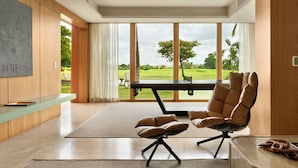 A modern living room with a large window, a flat-screen TV, and a comfortable seating area.
