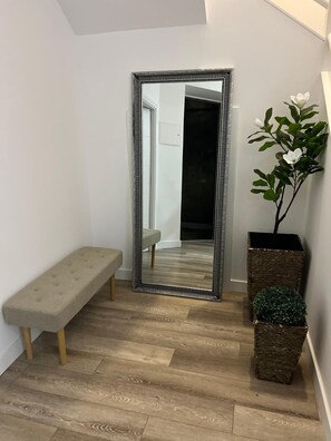 A room with a large mirror, a bench, and a potted plant. - A spacious and comfortable house, just 300 meters from the beach; pets welcome. (Buarcos)
