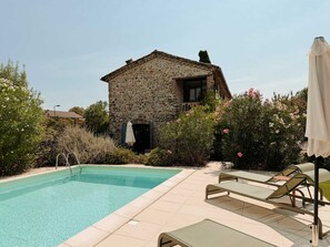 A stone building with a swimming pool, lounge chairs, and a covered area. - Historic stone house with a pool between the Cévennes and the Ardèche (Saint-Victor-de-Malcap)