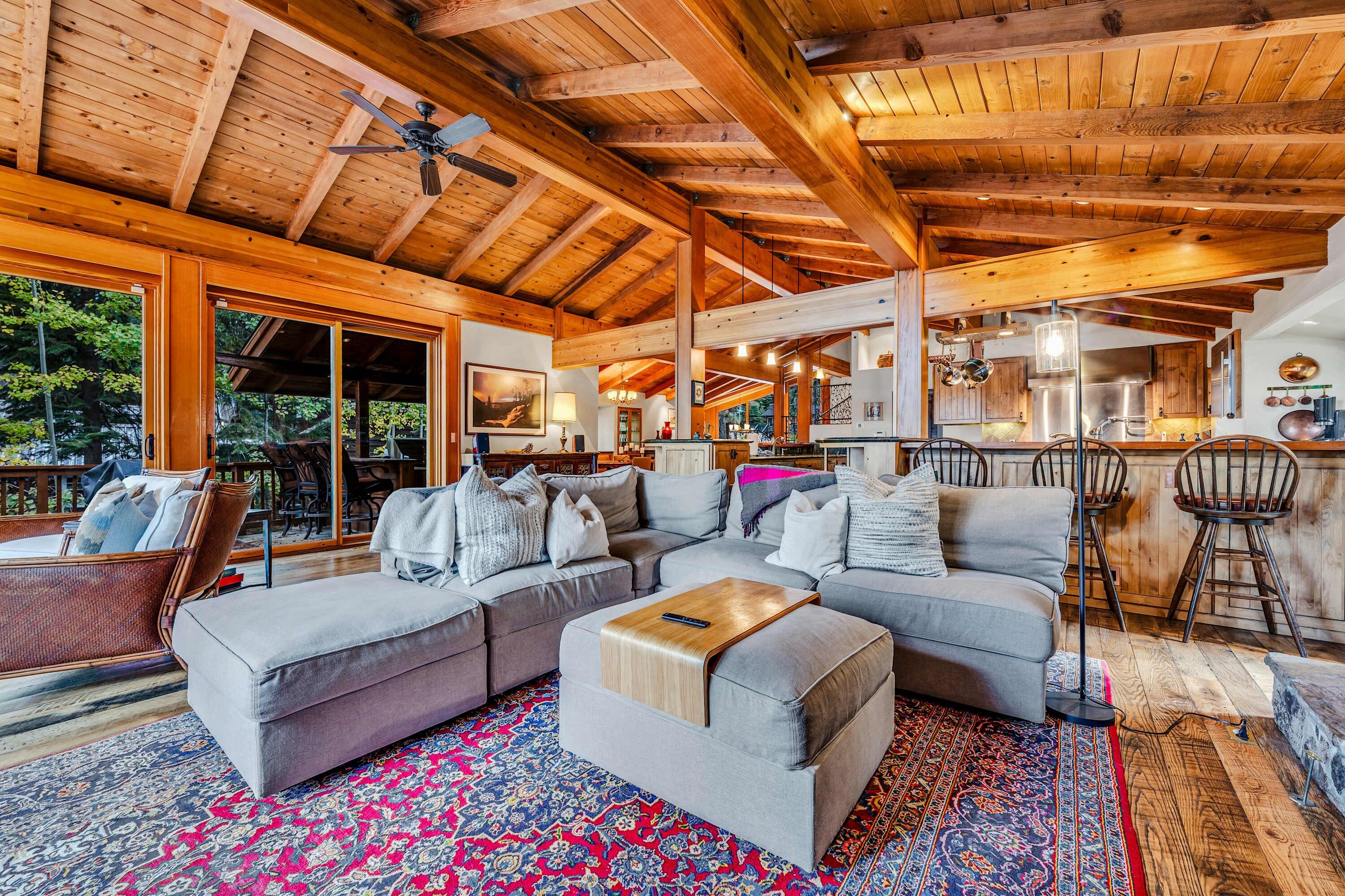 Living room (main floor): Wood-burning fireplace, 75" Smart TV, Bluetooth sound system, patio access, lake view