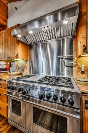 A stainless steel kitchen with a range hood, oven, and multiple burners. - Lake Tahoe Oasis | Deck & Grill & Hot Tub (Carnelian Bay)