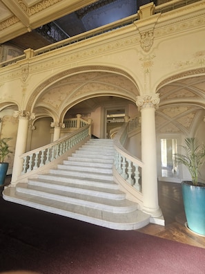 A grand staircase with ornate columns and a marble finish, leading to a higher level of the building. - Stay in a Belle Epoque Palace on the French Riviera (Menton)