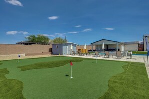 Ein Minigolfplatz mit Putting-Green, Sandfängen und einem kleinen Gebäude.
