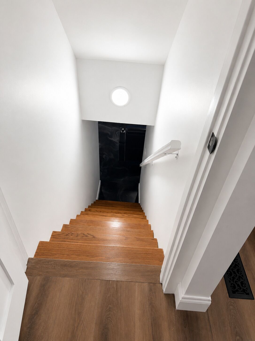 A staircase with wooden steps leading to a black door.