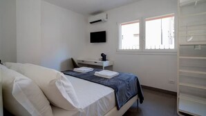 A bedroom with a bed, a desk, a television, and a window. - Marghera Smart Stay 1 | A Comfortable Room in Venice (Marghera)