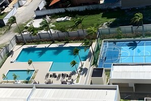 A rooftop pool with lounge chairs and a basketball court. - Apto 2 Qtos I Suíte I Lazer completo (Cabedelo)