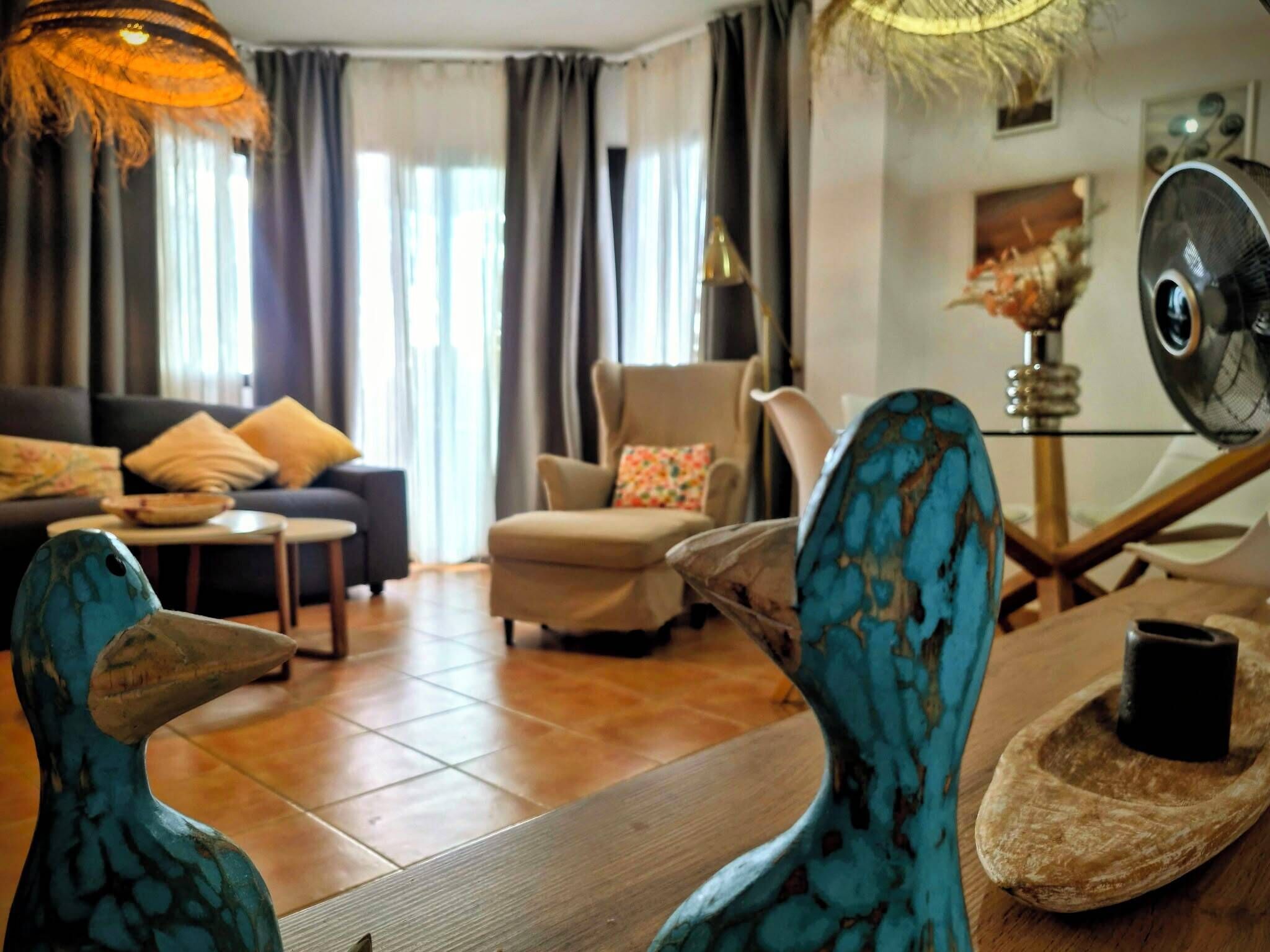 Un salon comprenant un canapé, des fauteuils, une table basse et des objets de décoration.