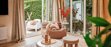 A modern living room with a sofa, a coffee table, and a side table with a vase of flowers.