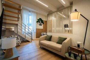 A modern living room with a staircase, a sofa, a coffee table, and a lamp. - Relax Retreat in Historic Florence - Private Sauna & Hydromassage (Firenze)