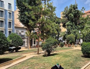 A courtyard with trees, a lawn, and buildings with balconies. - Apartment La Plaza 2 Deluxe With Balcony (Alicante)