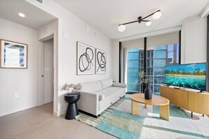A modern living room with a sofa, coffee table, and artwork on the wall. - The Crosby Worldcenter 2BR Palermo Home  (Miami)