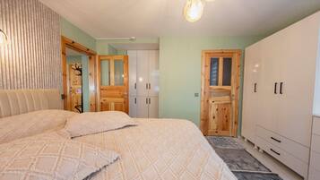 Un dormitorio con una cama grande, armario y espejo.