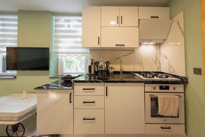 Una cocina compacta con estufa, horno y una pequeña encimera.