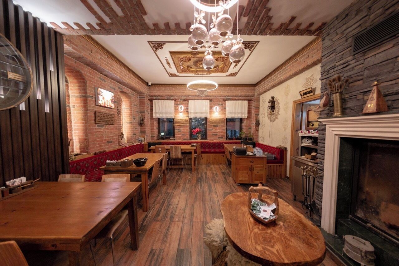 Un interior de restaurante con paredes de ladrillo, muebles de madera y chimenea.