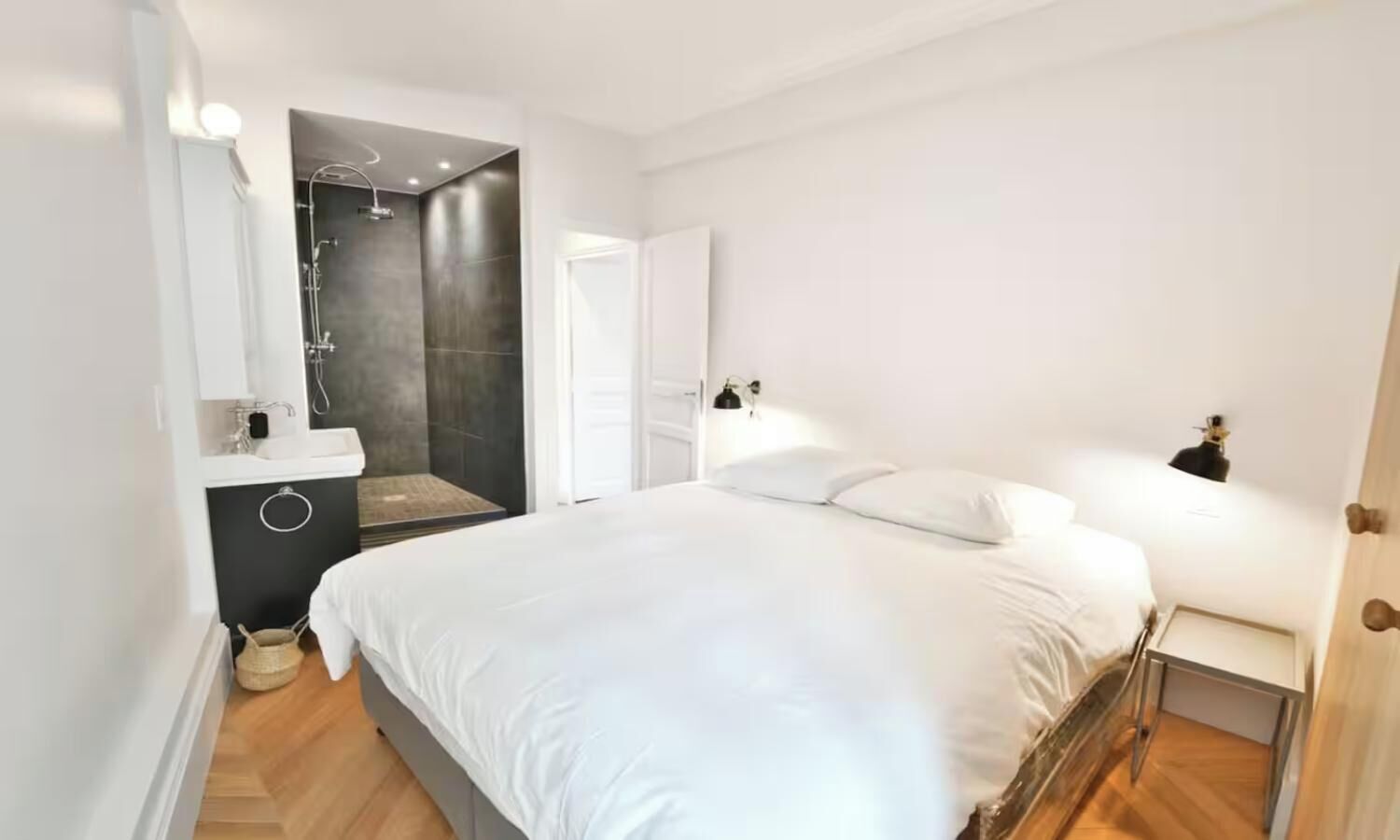 Une chambre à coucher avec un lit, une table de chevet et un espace douche.