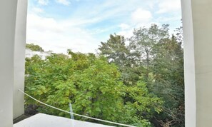 A balcony with a view of dense green foliage and trees. - COMBINING CLASSIC PARISIAN ARCHITECTURE WITH CONTEMPORARY COMFORT - 2 BEDROOM (Paris)