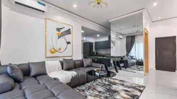 A modern living room with a sectional sofa, a coffee table, and a large mirror.