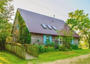 A rustic wooden house with a sloped roof, a wooden staircase, and a fenced yard. - Sandberg Retreat (Platteville)