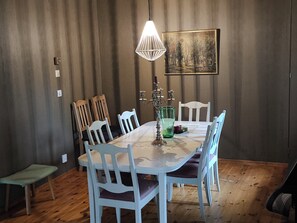 A dining area with a table, chairs, a candle holder, and a painting on the wall. - Scandinavian Forest Retreat • Sauna • Fireplace • Nature Experiences (Åsensbruk)
