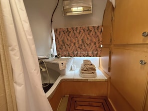 Ein kleines Badezimmer mit Dusche, Handtuchhalter und Toilette.