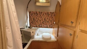 Ein kleines Badezimmer mit Toilette, Waschbecken und Duschbereich.