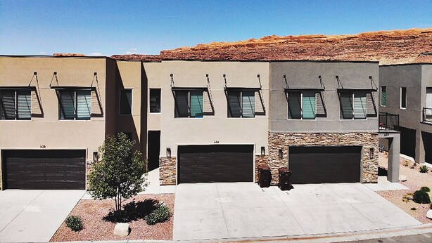 A row of modern, two-story houses with flat roofs, garage doors, and a clear blue sky. - Entrada at Moab 624 and 632 (Moab)