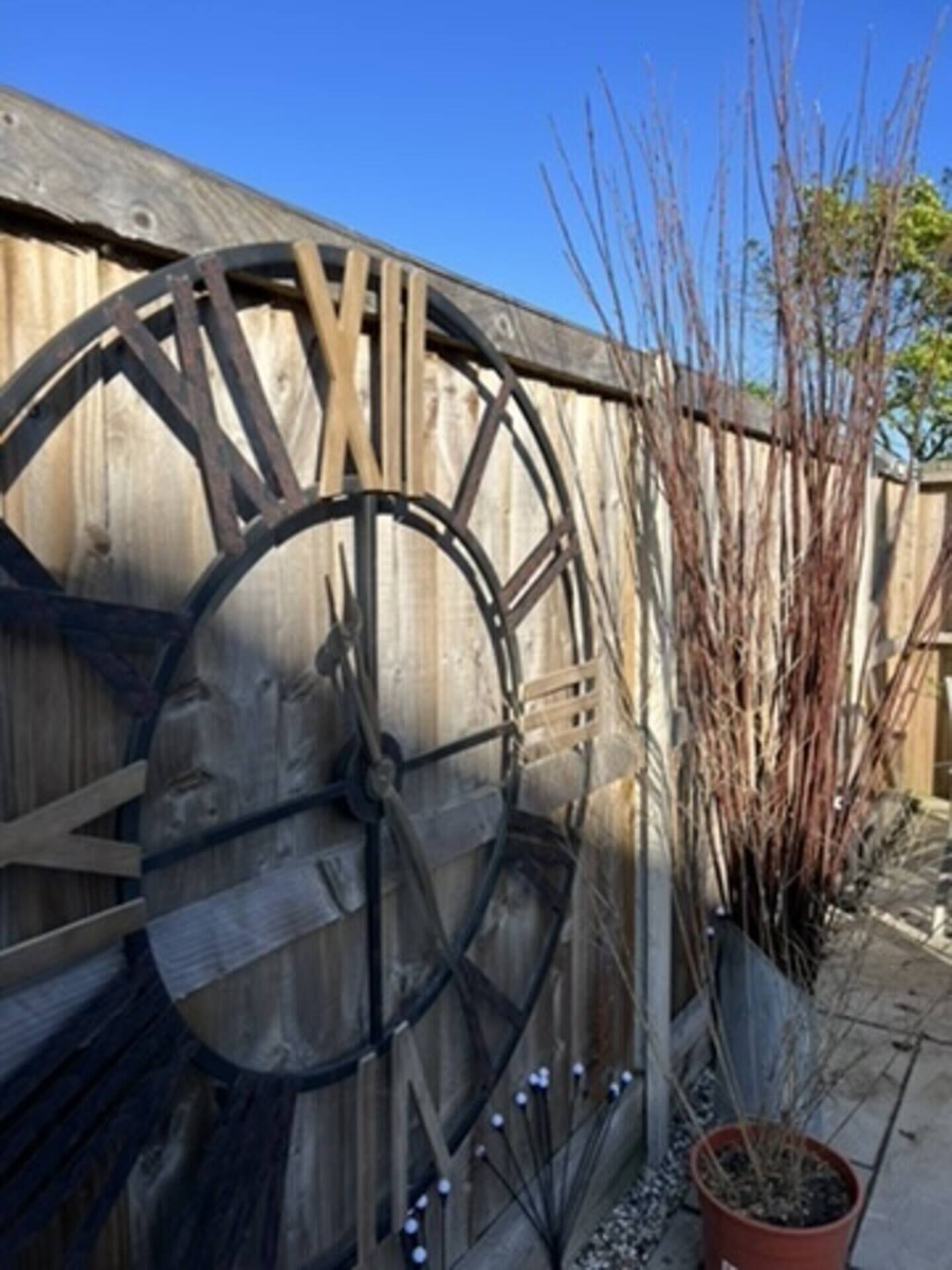 A large wooden wheel structure, possibly a decorative element, attached to a wooden fence.