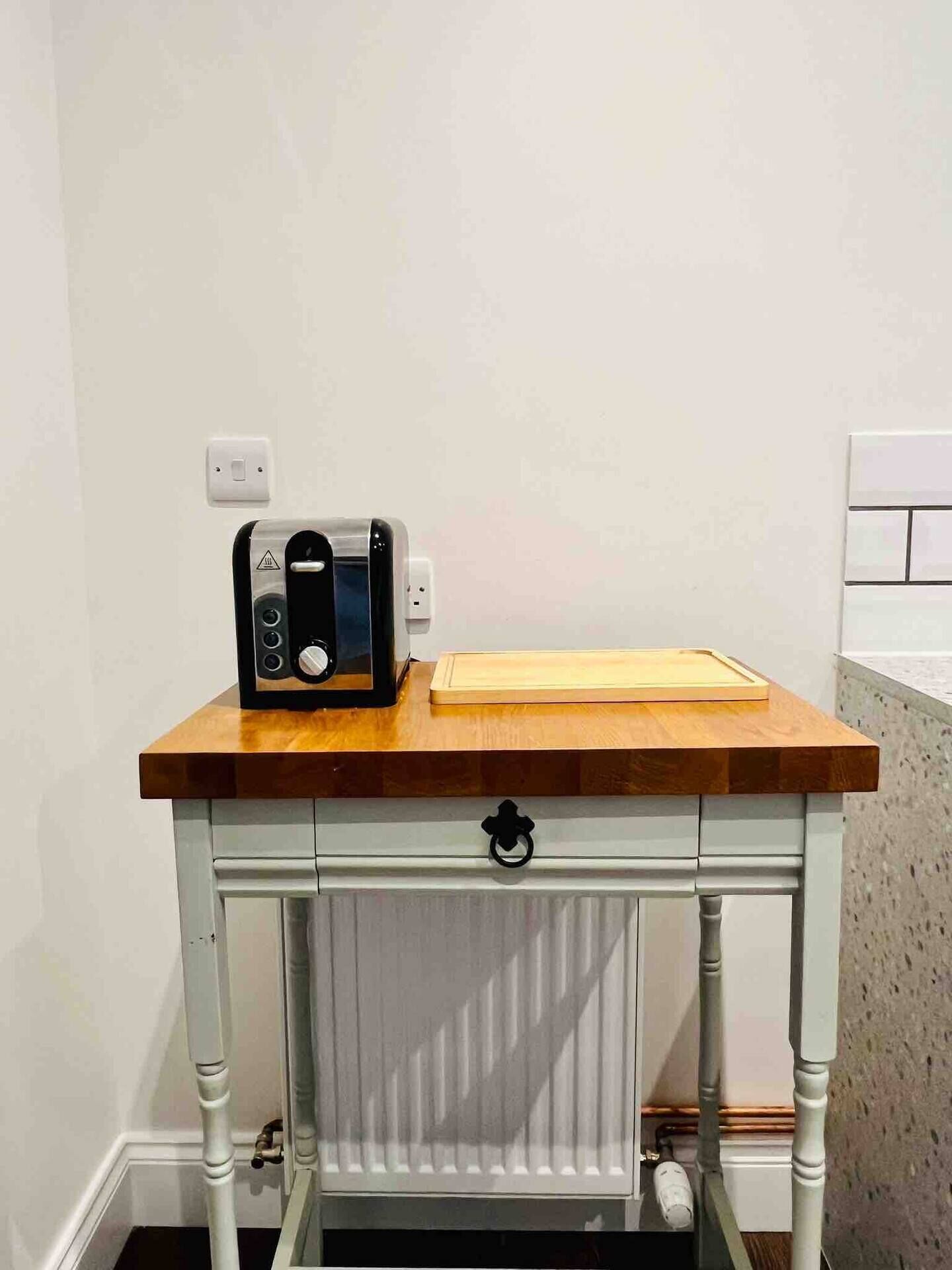 Una encimera de cocina con un tostador y una tabla de cortar.