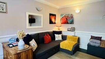 A living room with a sofa, a coffee table, and a lamp.