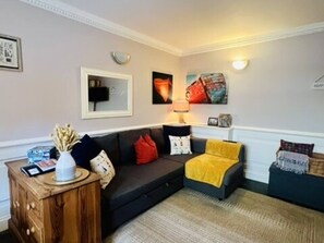 A living room with a sofa, a coffee table, and a lamp.