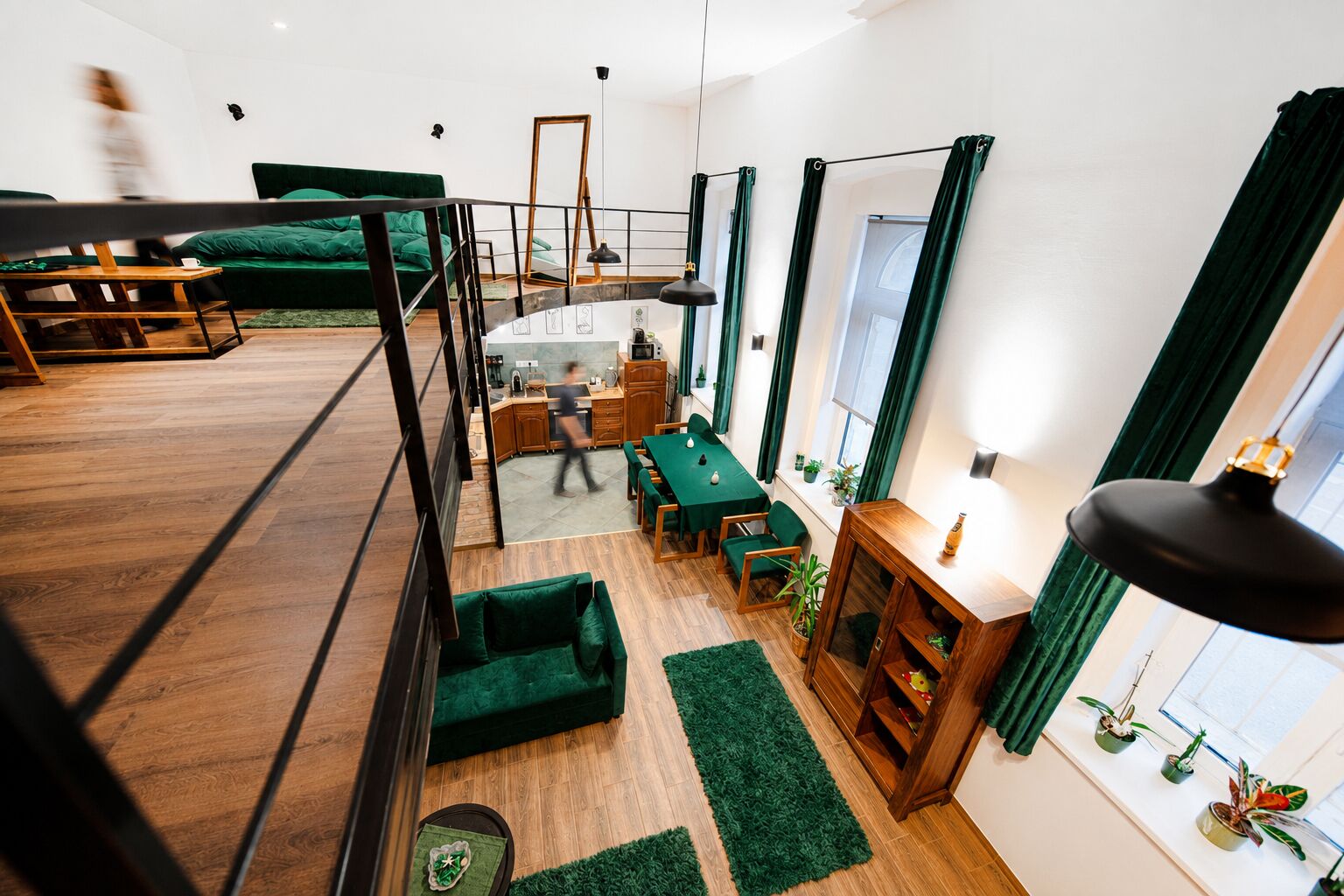 A modern interior with a loft-style bedroom, a dining area, and a kitchen.