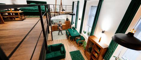 A modern interior with a loft-style bedroom, a dining area, and a kitchen.