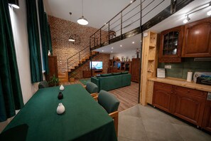 Een moderne woonruimte met een eethoek, keuken en een trap naar een bovenverdieping.