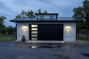 Eine Garage mit einer schwarzen Tür und zwei Wandleuchten.
