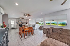 A modern kitchen with a dining area, a living room with a sofa, and a view of the ocean. - Ocean-beach Front Family Dream Vacation Ewa Beach Home W/full Beach Access (Ewa Beach)