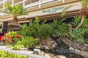 A hotel named 'Island Colony' with a landscaped garden featuring a small waterfall and various tropical plants. - Mountain & Golf Course Views Family Island Colony Condo & Lots of Amenities (Honolulu)