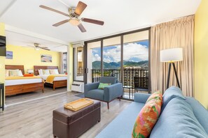 A hotel room with a balcony, a bed, a sofa, and a ceiling fan. - Golf Course-city View Condo at the Waikiki Banyan By the Beach & Restaurants (Honolulu)