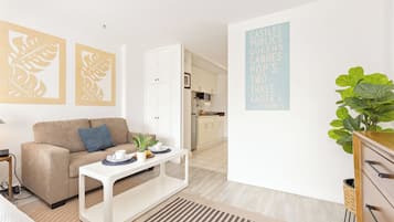 Uma sala de estar moderna com sofá, mesa de centro e arte decorativa com folhas.