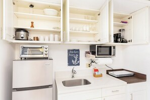 A kitchen with a built-in toaster, a microwave, a sink, and a refrigerator. - Mountain-city View W/full Kitchen at Ilikai Marina Near Shops & Restaurants (Honolulu)