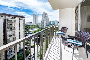 A balcony with a view of a cityscape, featuring high-rise buildings and greenery. - Fairway Villa in the Heart of Waikiki by the Beach W/rooftop Pool & Amenities (Honolulu)