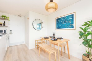 A modern kitchen with white cabinets, a microwave, and a hanging light fixture. - Golf Course & MT Renovated Condo at Island Colony & Spectacular Amenities (Honolulu)