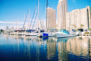 A marina with multiple boats docked, surrounded by tall buildings. - Ilikai Hotel City View Condo Steps Away From Beach W/full Kitchen & Free Wifi (Honolulu)