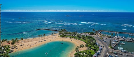 Uma área costeira com praia, estacionamento e marina.