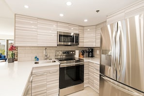 A modern kitchen with stainless steel appliances, a built-in oven, and a microwave. - Ilikai Hotel City View Condo Steps Away From Beach W/full Kitchen & Free Wifi (Honolulu)